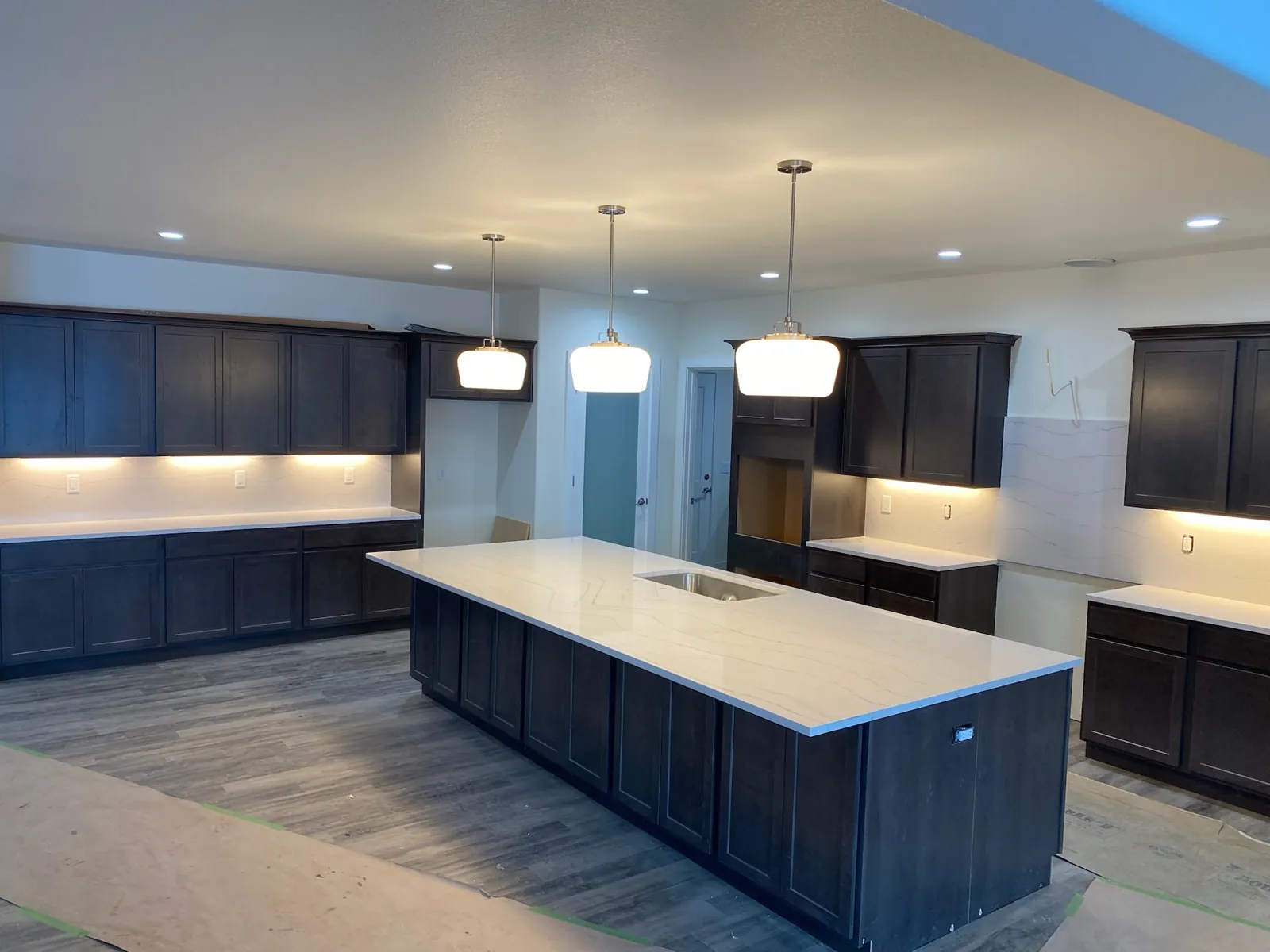 White quartz kitchen island with an undermount sink and mitered edges in a new-construction Dayton, Nevada home