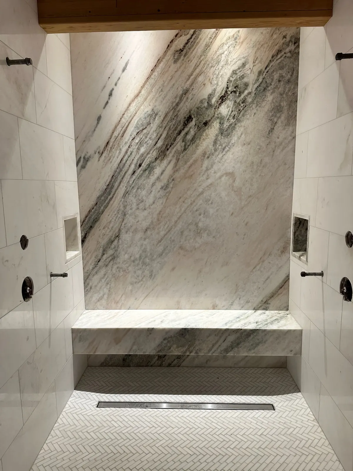 Floating dolomite shower bench and dolomite feature wall in a walk-in shower in Incline Village